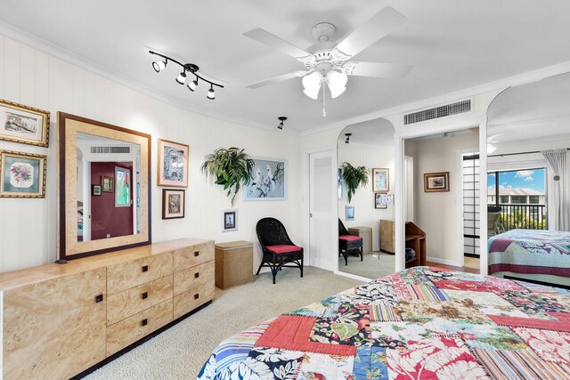 carpeted bedroom featuring crown molding, rail lighting, access to outside, and ceiling fan