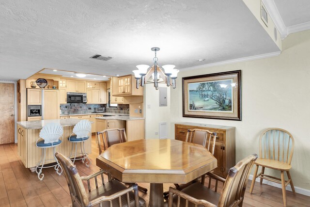 dining area featuring a notable chandelier, wood-type flooring, ornamental molding, and a textured ceiling