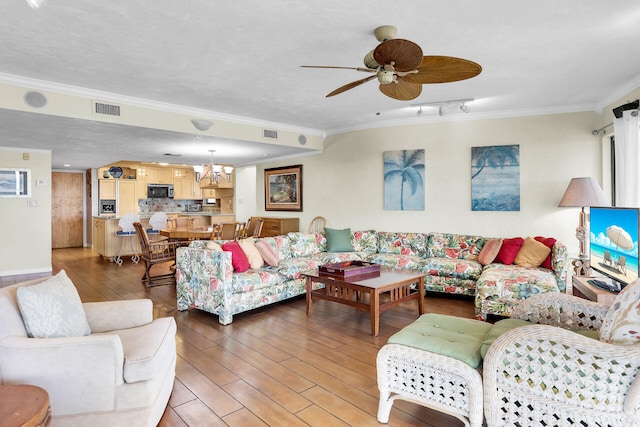 living room featuring crown molding, hardwood / wood-style flooring, track lighting, a textured ceiling, and ceiling fan with notable chandelier