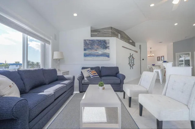 living room with ceiling fan with notable chandelier and vaulted ceiling