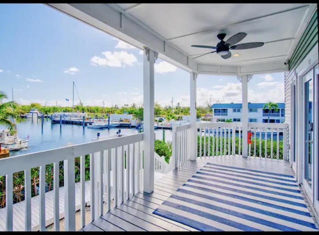 wooden deck featuring ceiling fan and a water view