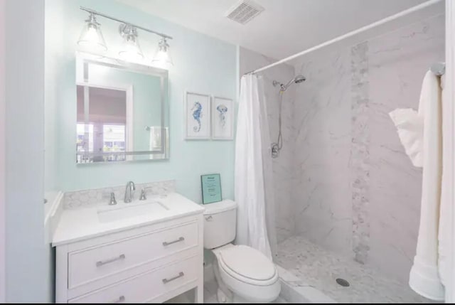 bathroom with vanity, curtained shower, and toilet