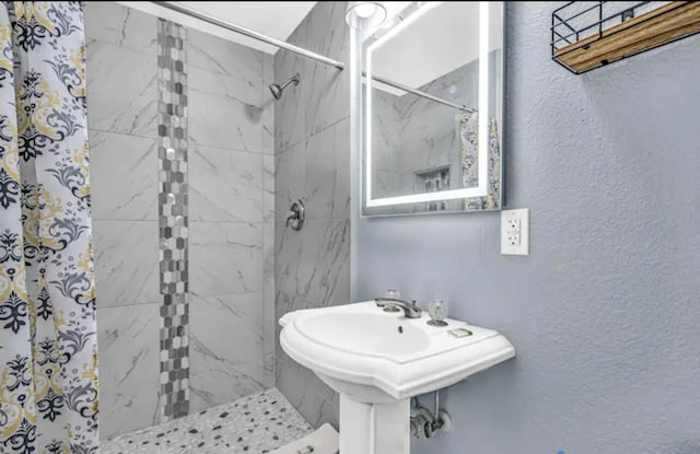 bathroom with sink and a tile shower