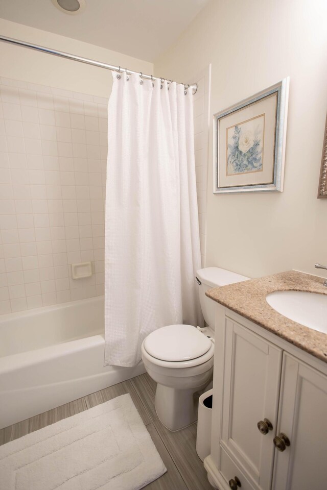 full bathroom with shower / tub combo with curtain, vanity, and toilet