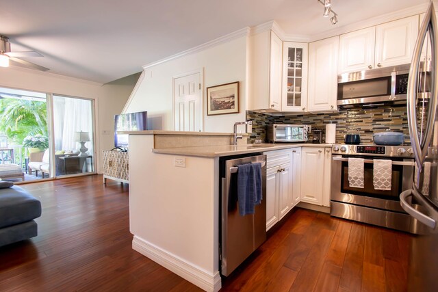 kitchen featuring stainless steel appliances, dark hardwood / wood-style flooring, kitchen peninsula, and white cabinets