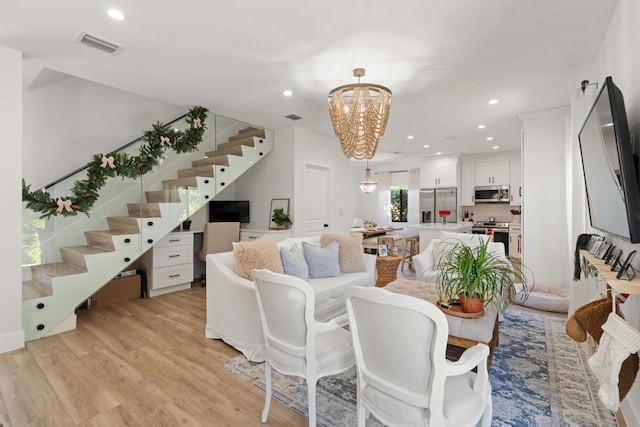 living room with an inviting chandelier and light hardwood / wood-style floors