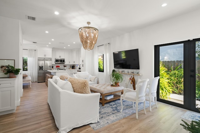 living room featuring an inviting chandelier and light hardwood / wood-style floors