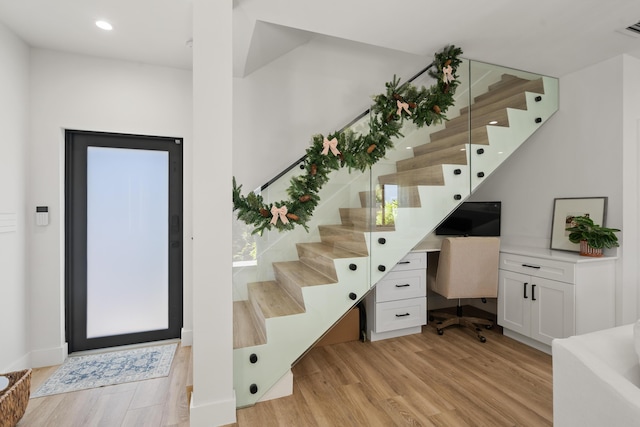 interior space with built in desk and light hardwood / wood-style floors