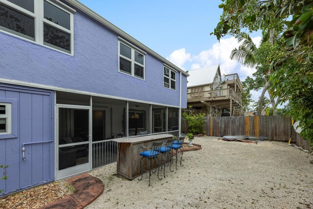 back of house featuring a patio and exterior bar