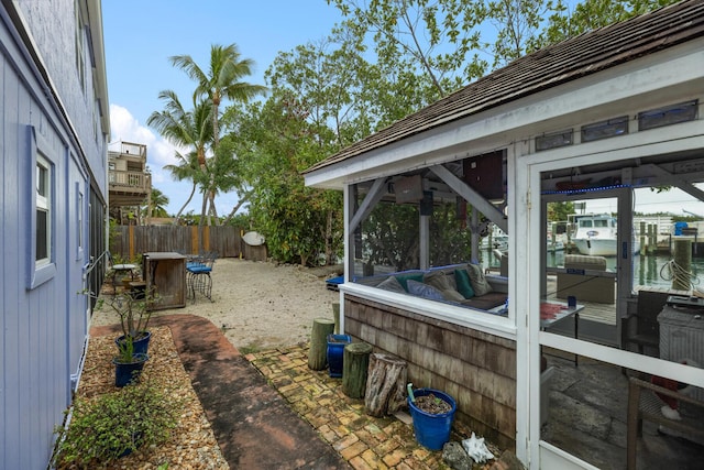 view of yard featuring a water view and a sunroom