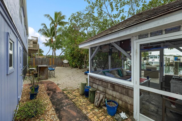 view of yard featuring a water view and a sunroom