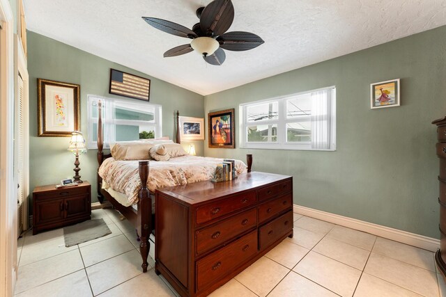 bedroom with light tile patterned floors, a textured ceiling, and ceiling fan