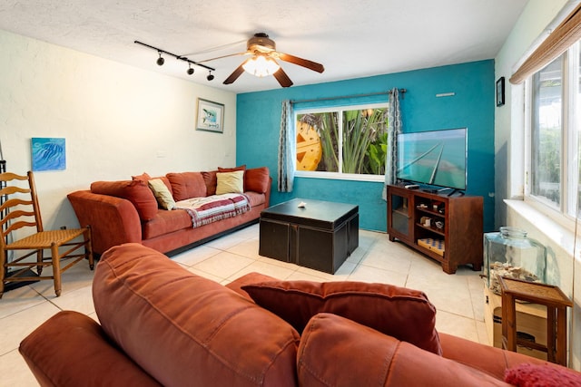 tiled living room with ceiling fan, rail lighting, and a textured ceiling