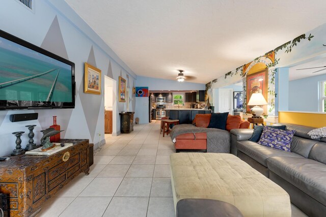 living room with light tile patterned flooring, ceiling fan, and vaulted ceiling