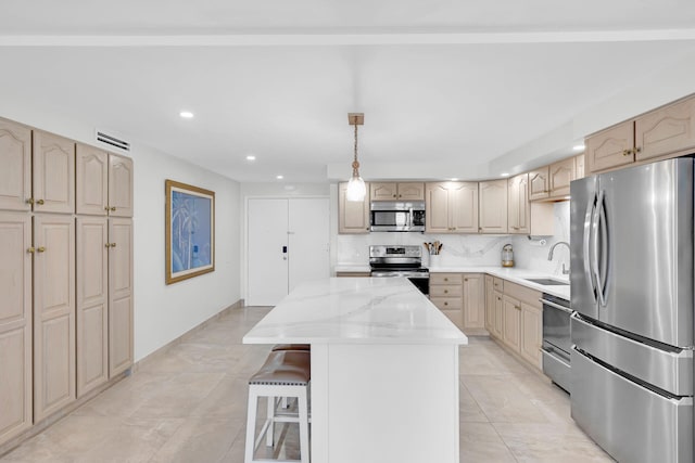 kitchen with pendant lighting, sink, stainless steel appliances, a center island, and a kitchen bar