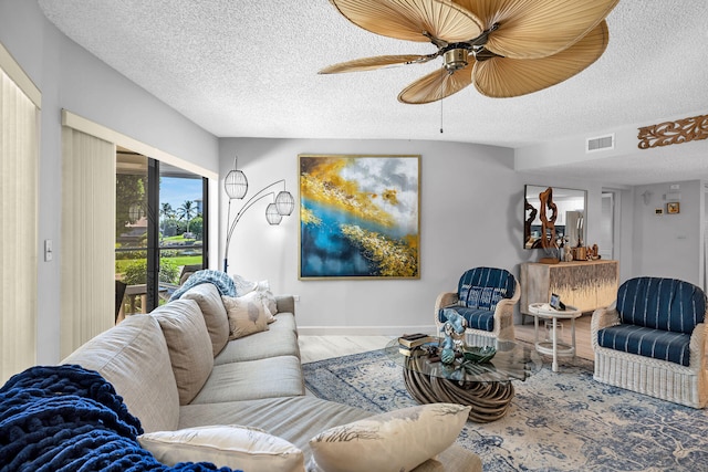 living room with visible vents, a ceiling fan, a textured ceiling, wood finished floors, and baseboards