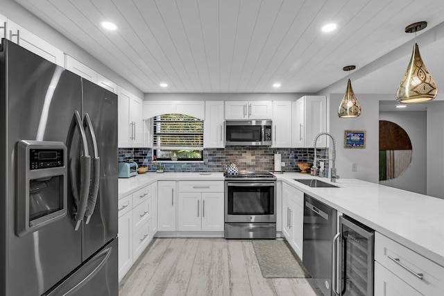 kitchen with wine cooler, white cabinets, stainless steel appliances, and a sink