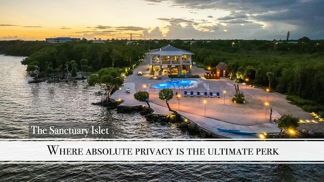 pool at dusk featuring a water view