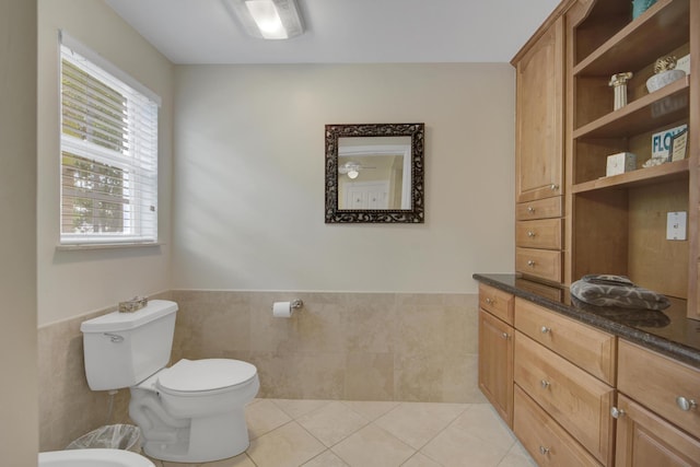 bathroom featuring vanity, tile walls, tile patterned floors, and toilet