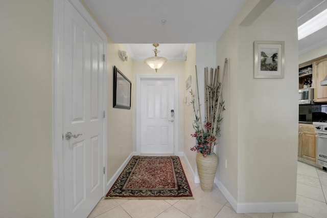 entryway featuring light tile patterned floors and crown molding