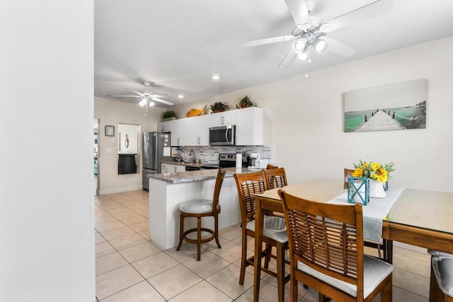 tiled dining area with ceiling fan