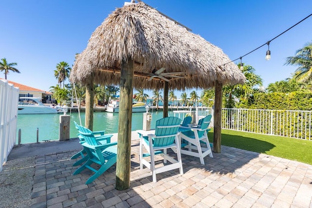 view of patio / terrace featuring a water view, ceiling fan, and a gazebo