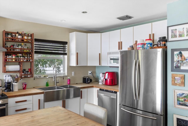 2525 Patterson Ave, Key West, FL 33040 - kitchen featuring stainless steel appliances, butcher block counters, a sink, white cabinetry, and recessed lighting
