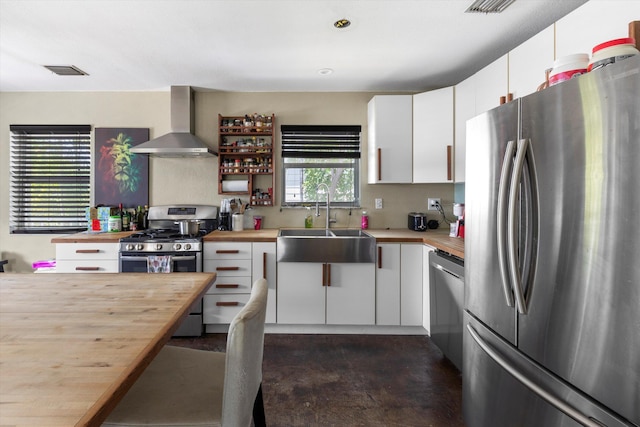 2525 Patterson Ave, Key West, FL 33040 - kitchen with stainless steel appliances, wall chimney exhaust hood, wooden counters, a sink, and concrete flooring