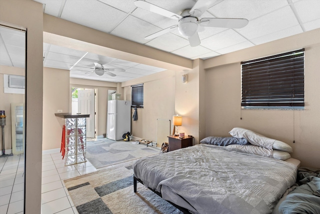 2525 Patterson Ave, Key West, FL 33040 - tiled bedroom with freestanding refrigerator, a drop ceiling, ceiling fan, and baseboards