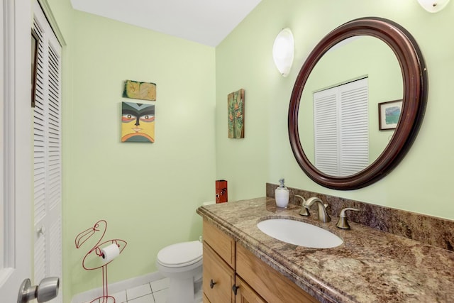 half bath featuring baseboards, toilet, tile patterned flooring, vanity, and a closet