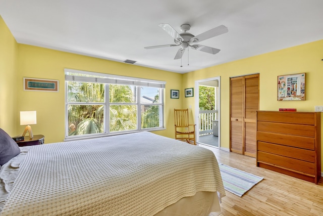 bedroom featuring light wood-style flooring, visible vents, and ceiling fan