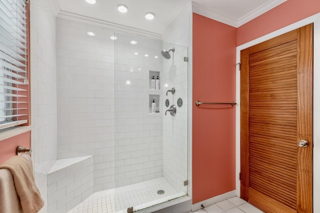 bathroom featuring crown molding, a shower stall, baseboards, and tile patterned floors