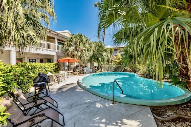 pool featuring a patio area and fence