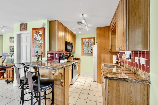 kitchen featuring visible vents, electric range oven, black microwave, a sink, and light tile patterned flooring