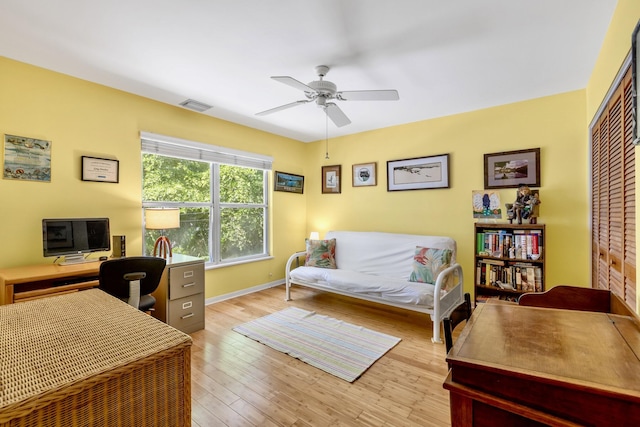 office with light wood-type flooring, visible vents, ceiling fan, and baseboards