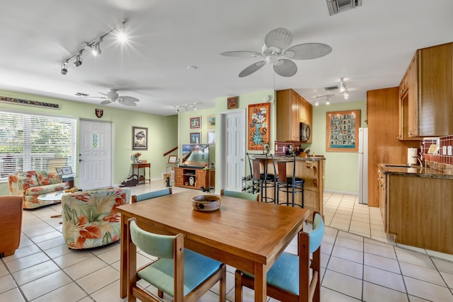 dining room with light tile patterned floors, visible vents, a ceiling fan, and rail lighting