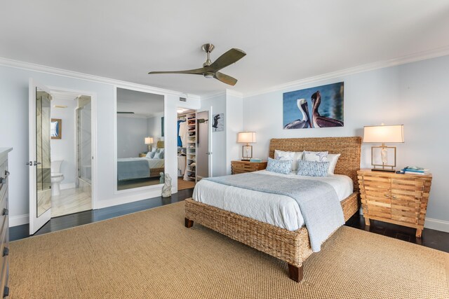 bedroom featuring crown molding, a walk in closet, dark hardwood / wood-style flooring, and a closet