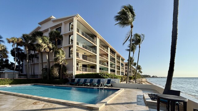 view of swimming pool with a patio and a water view