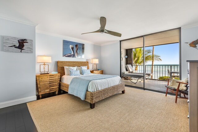 bedroom with a water view, ornamental molding, hardwood / wood-style floors, and access to outside