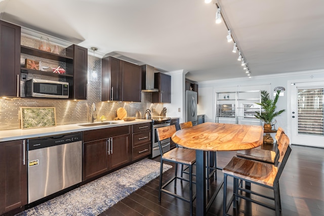 kitchen featuring sink, wall chimney range hood, appliances with stainless steel finishes, backsplash, and dark hardwood / wood-style floors