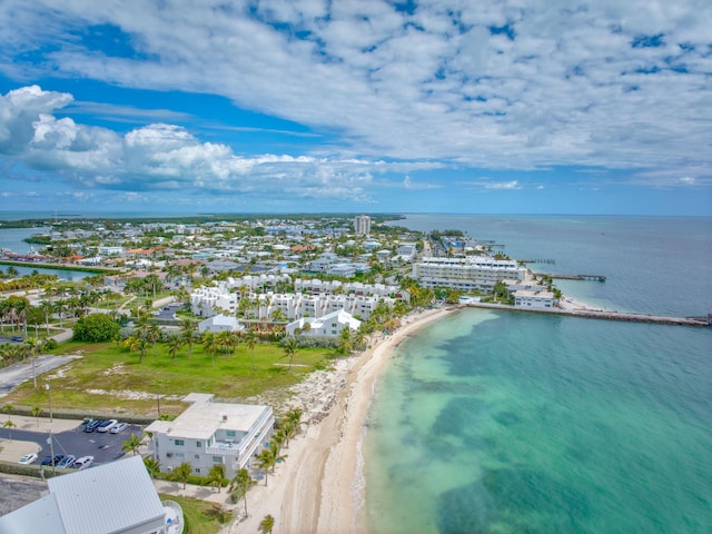 birds eye view of property with a water view and a beach view