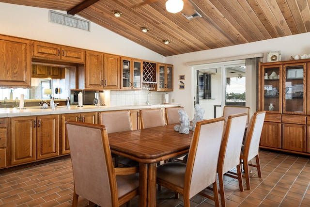 dining space featuring wood ceiling and lofted ceiling with beams