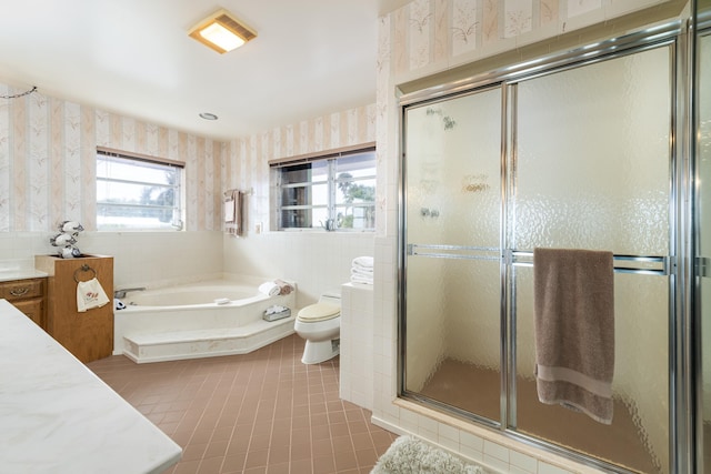 full bathroom featuring tile patterned flooring, tile walls, vanity, shower with separate bathtub, and toilet