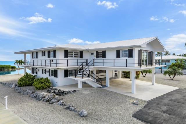 view of front facade with a carport and a water view