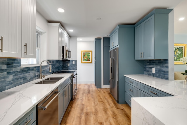 1706 Seminary St, Key West, FL 33040 - kitchen featuring appliances with stainless steel finishes, light stone counters, light wood finished floors, recessed lighting, and backsplash