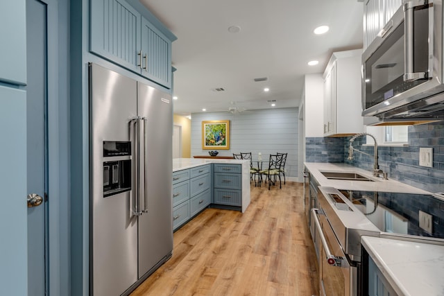1706 Seminary St, Key West, FL 33040 - kitchen with appliances with stainless steel finishes, ceiling fan, light wood finished floors, light stone counters, and decorative backsplash