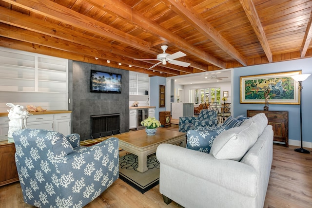 1706 Seminary St, Key West, FL 33040 - living room with beverage cooler, a wood ceiling with exposed beams, a tile fireplace, ceiling fan, and light wood-style floors