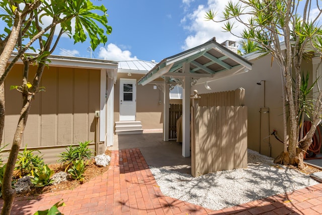1706 Seminary St, Key West, FL 33040 - view of exterior entry featuring stucco siding, a standing seam roof, and a metal roof