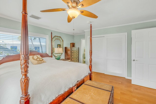 bedroom featuring wood-type flooring, ornamental molding, ceiling fan, and a closet