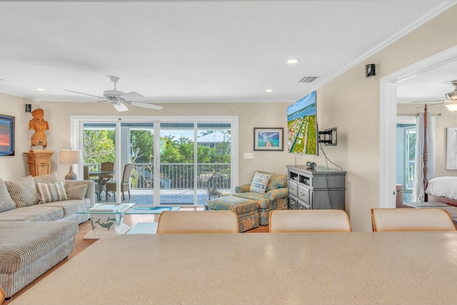 living room with crown molding and ceiling fan